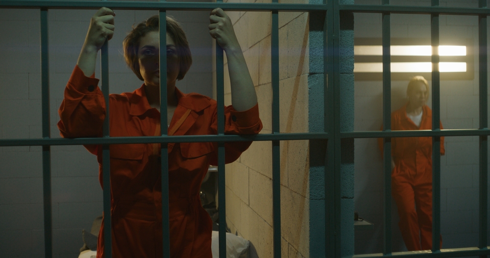 Youth detainee standing behind cell bars inside a juvenile detention center, representing survivors involved in juvenile hall sexual abuse lawsuits by File Abuse Lawsuit
