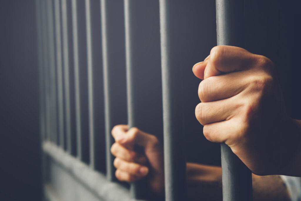Woman holding prison bars - sexual assault at FCI Dublin - File Abuse Lawsuit