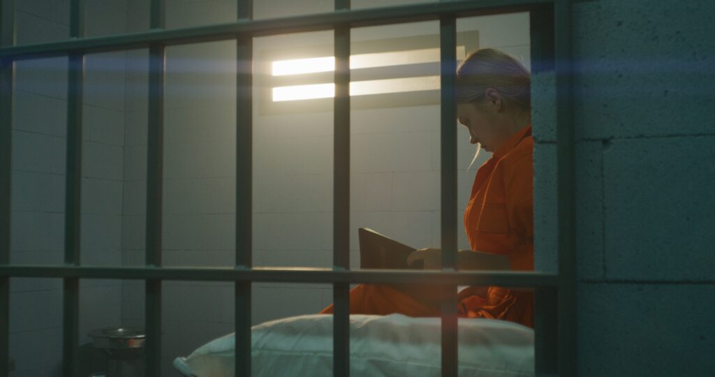 Woman reading in prison cell - sexual assault at FCI Dublin - File Abuse Lawsuit