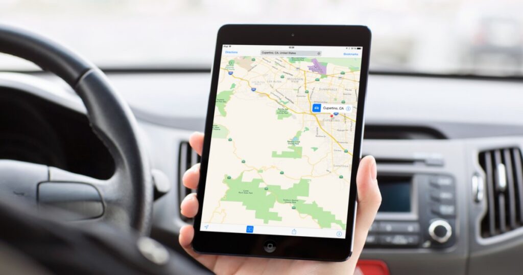 Person using Apple Find My location tracking on a mobile device inside a car
